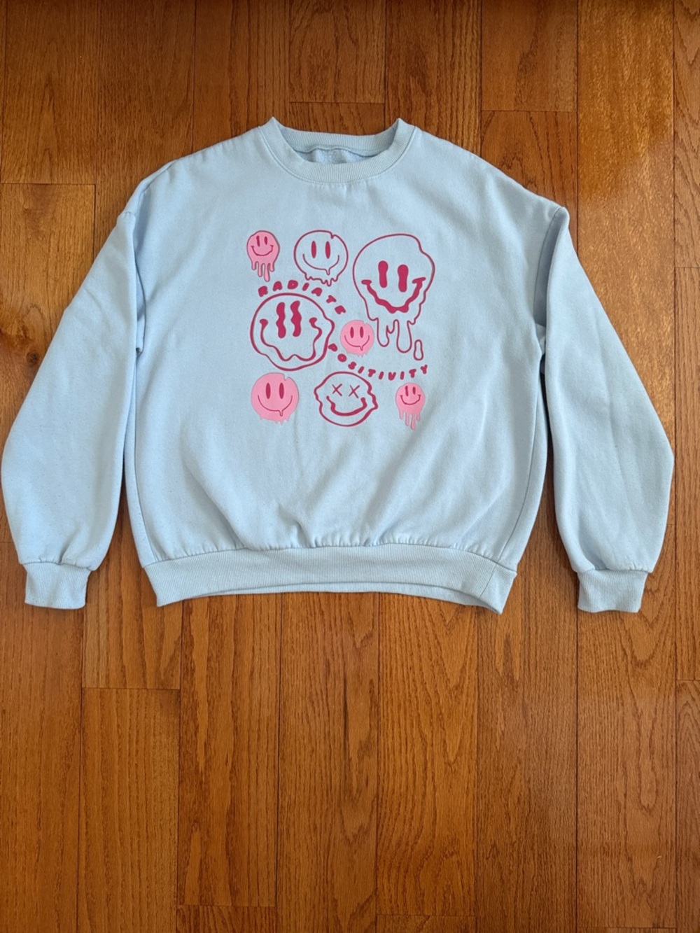Light Blue Crewneck with Pink Melting Smiley Graphic